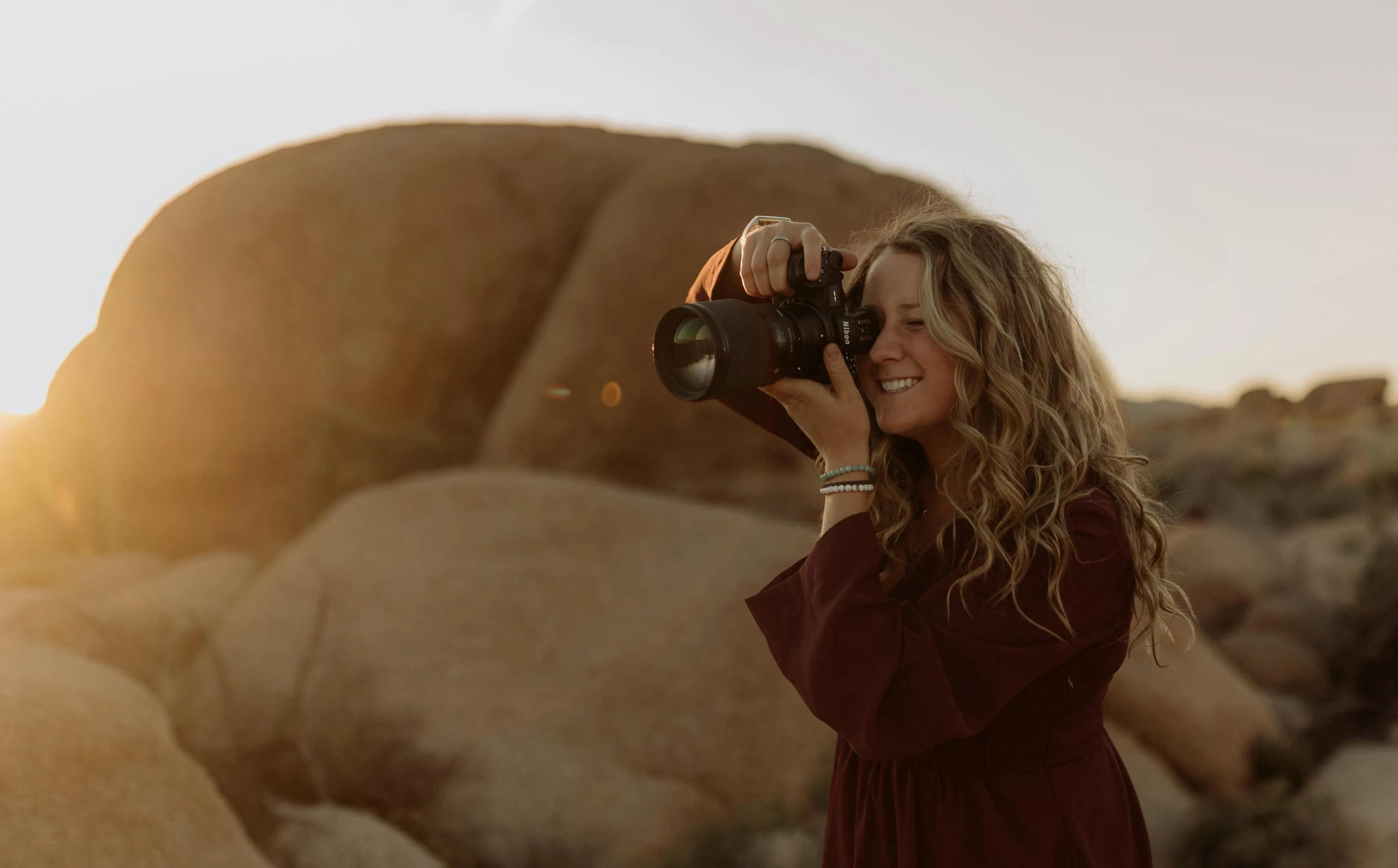 Hayley taking a photo of a mountain landscape with a camera.